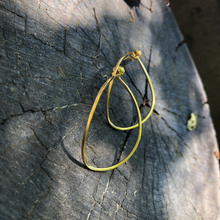 Load image into Gallery viewer, Gold hoop earrings on a textured dark surface