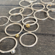 Load image into Gallery viewer, Collection of silver rings with small beads on a wooden surface