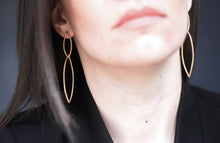 Load image into Gallery viewer, Close-up of a person wearing gold dangle handmade earrings